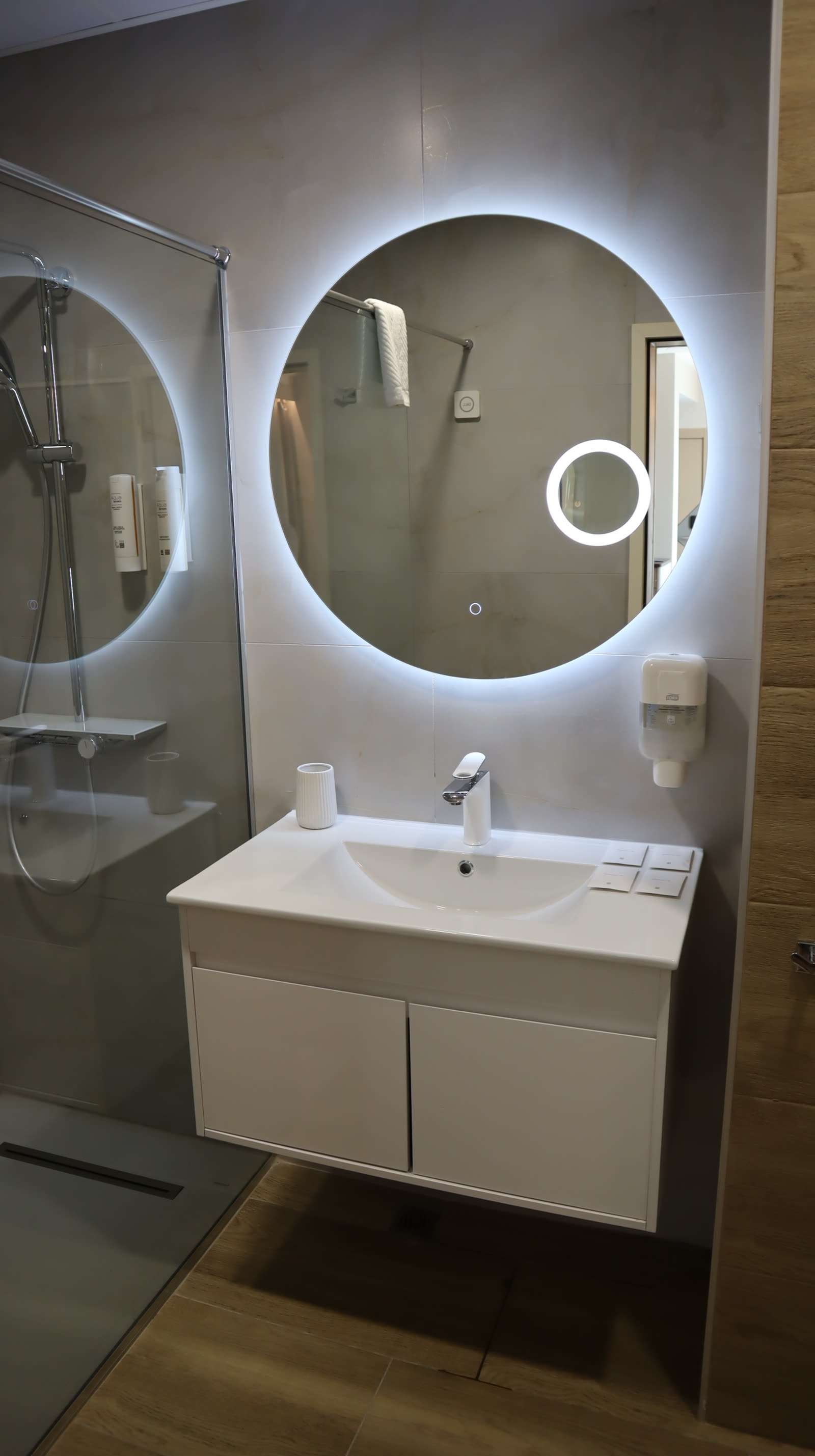 Badezimmer mit Duschkabine und LED-Spiegel